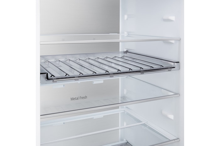 LG Unterer Gefrierschrank (GBBS726CPY) bündig installiert in hoher warmer beigefarbener Wand mit weißen Pfeilen, welche auf die Oberseite und die vorderen Oberflächen zeigen