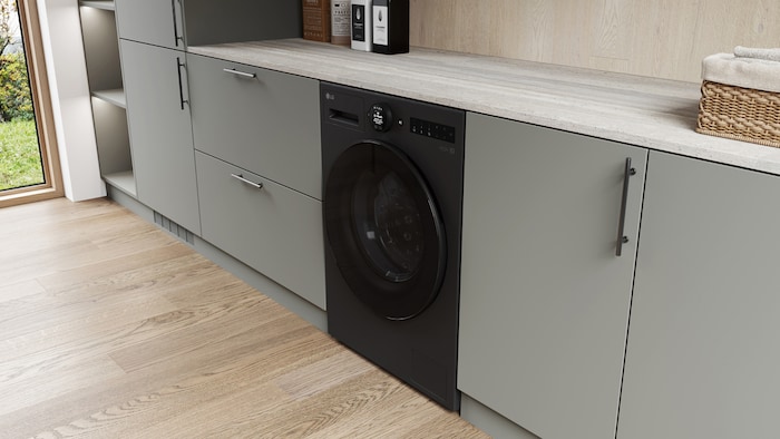 Die LG 13 kg Waschmaschine F4WX803YB in Matte Black, installiert in einer modernen Küche, um ihr schlankes, integriertes Design zu zeigen, mit Energieeffizienzklasse A-20%.