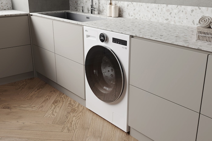 Die weiße LG 9 kg Waschmaschine F4WX9092, installiert in einer modernen Küche, um ihr schlankes, integriertes Design zu zeigen, mit Energieeffizienzklasse A-55%.