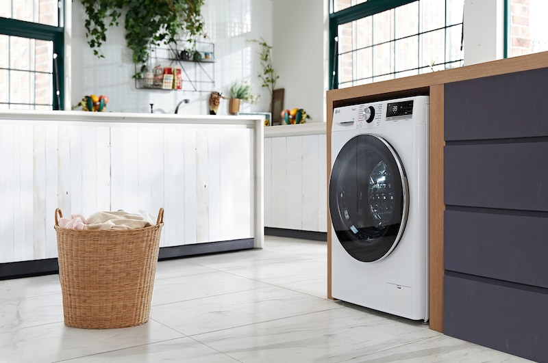Die weiße LG 11 kg Waschmaschine F4W11A mit elegantem Design, installiert in einem modernen Waschraum, mit Energieeffizienzklasse A-10%.