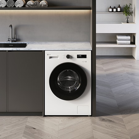 Die LG 9 kg Waschmaschine F4WB309Y in Essence White, unterbaufähig in einem modernen Waschraum installiert, mit Energieeffizienzklasse A.