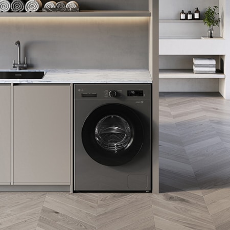Die LG 8 kg Waschmaschine F4WB308YB in der Farbe Dark Stone, unterbaufähig installiert in einem modernen Waschraum, mit Energieeffizienzklasse A.