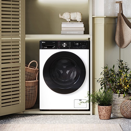 Die weiße LG 9 kg Waschmaschine F4WR709YP mit markantem schwarzem Bullaugenring, installiert in einem stilvollen, modernen Waschraum, mit Energieeffizienzklasse A-10%.