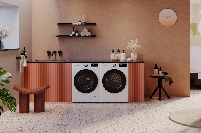 Der weiße LG 8 kg Trockner RT80V9W, als Paar neben einer passenden Waschmaschine in einem stilvollen, modernen Waschraum installiert, mit Energieeffizienzklasse C.