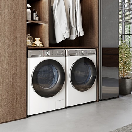 Der weiße LG 10 kg Trockner V9A2XT, als Paar neben einer passenden Waschmaschine in einem hochwertigen Ankleidezimmer installiert, mit Energieeffizienzklasse C.