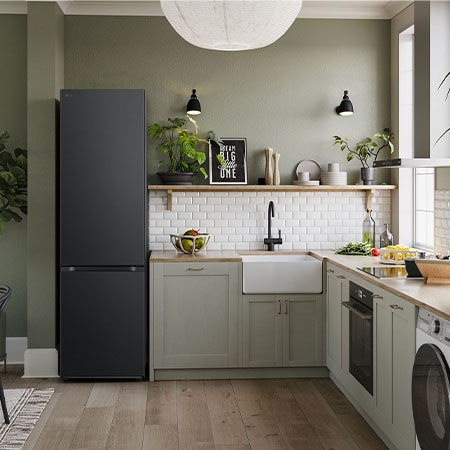 LG Kühl-Gefrierkombination GBV7280AEV in Essence Black Steel, 203 cm hoch, integriert in eine moderne, grüne Küche, demonstriert ihr elegantes Flat Door Design.