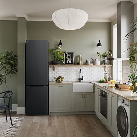 LG Kühl-Gefrierkombination GBV3200CEP in Essence Matte Black, 203 cm hoch, integriert in eine moderne, grüne Küche, demonstriert ihr elegantes Flat Door Design.