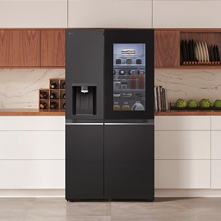 LG Side-by-Side Kühlschrank GSGV91EVAD in mattem Schwarzstahl mit InstaView™ Door-in-Door® und Wasserspender, elegant in eine moderne Küche mit weißer und hölzerner Arbeitsplatte integriert.