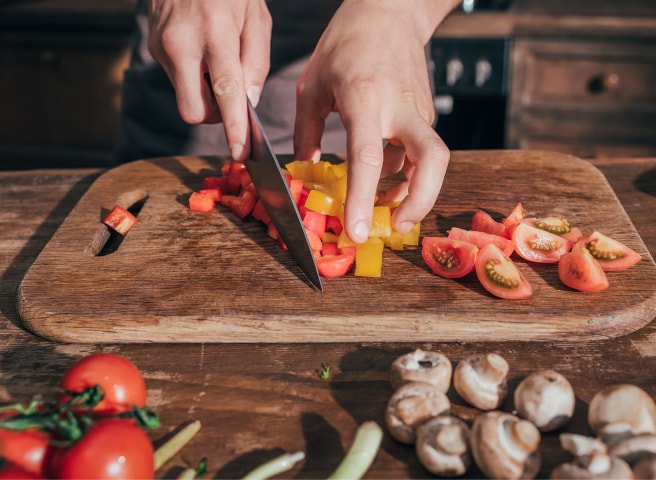 Bild vom Tomatenschneiden auf einem Schneidebrett mit einem Messer.