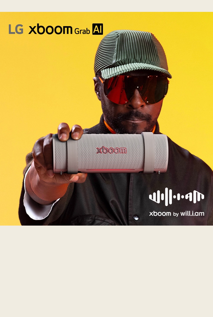 will.i.am in weißem Outfit und Sonnenbrille hält xboom Grab direkt neben sein Gesicht.