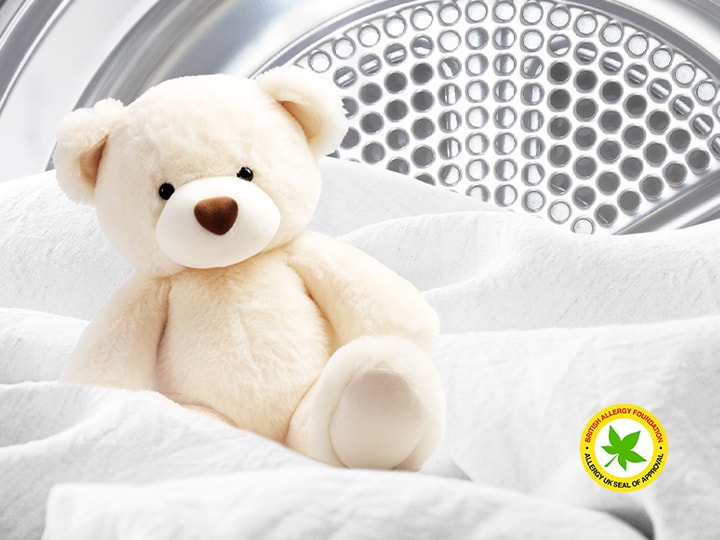 Bild einer Decke und eines Teddybärs in einem LG Trockner mit dem Logo der British Allergy Foundation
