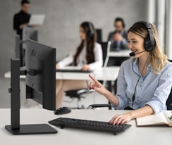 Eine Frau mit Headset spricht mit einem Kunden in einem Callcenter.