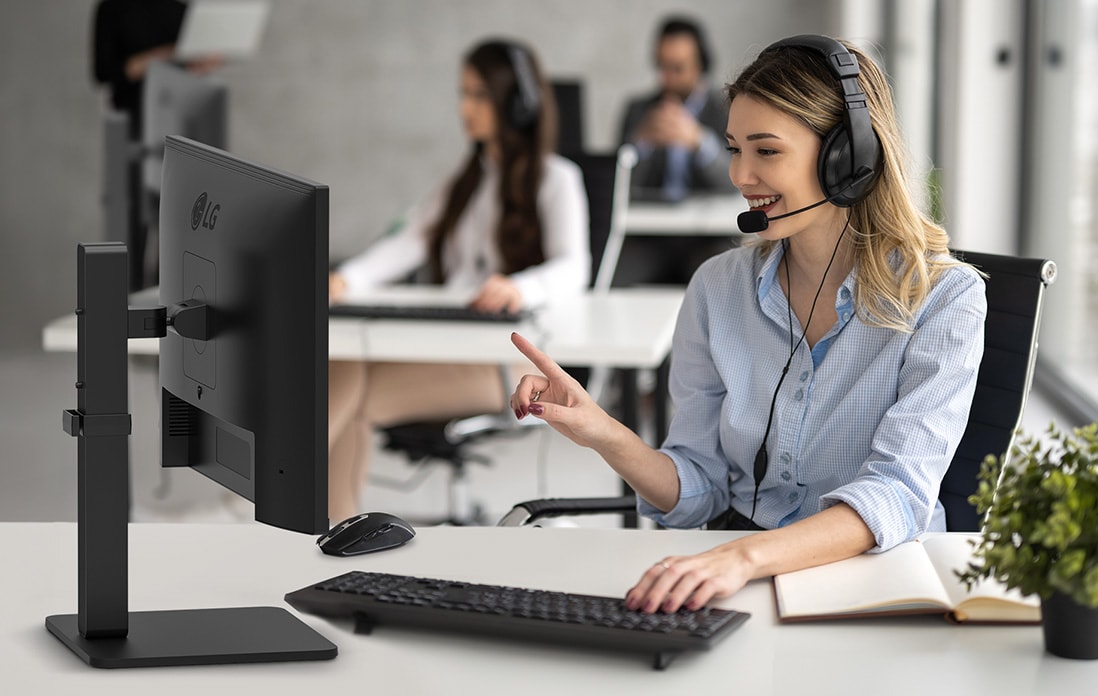 Eine Frau mit Headset spricht mit einem Kunden in einem Callcenter.