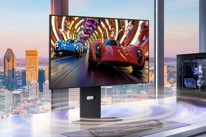 Ein eleganter Gaming-Monitor auf einem modernen Schreibtisch zeigt ein Hochgeschwindigkeits-Rennspiel mit zwei Sportwagen, einem roten und einem blauen, die durch einen lebhaften Tunnel rasen. Das Setup befindet sich vor großen Fenstern mit Blick auf die Skyline der Stadt bei Sonnenuntergang, mit einem Gaming-PC auf der rechten Seite und Soundwave-Grafiken, die immersive Audioeffekte veranschaulichen.