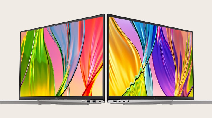 Das Bild zeigt zwei Laptops, die Rücken an Rücken platziert sind, und präsentiert leuchtende, farbenfrohe Bildschirme mit dünnen Rändern, die lebendige Bilder und ein schlankes Design betonen.