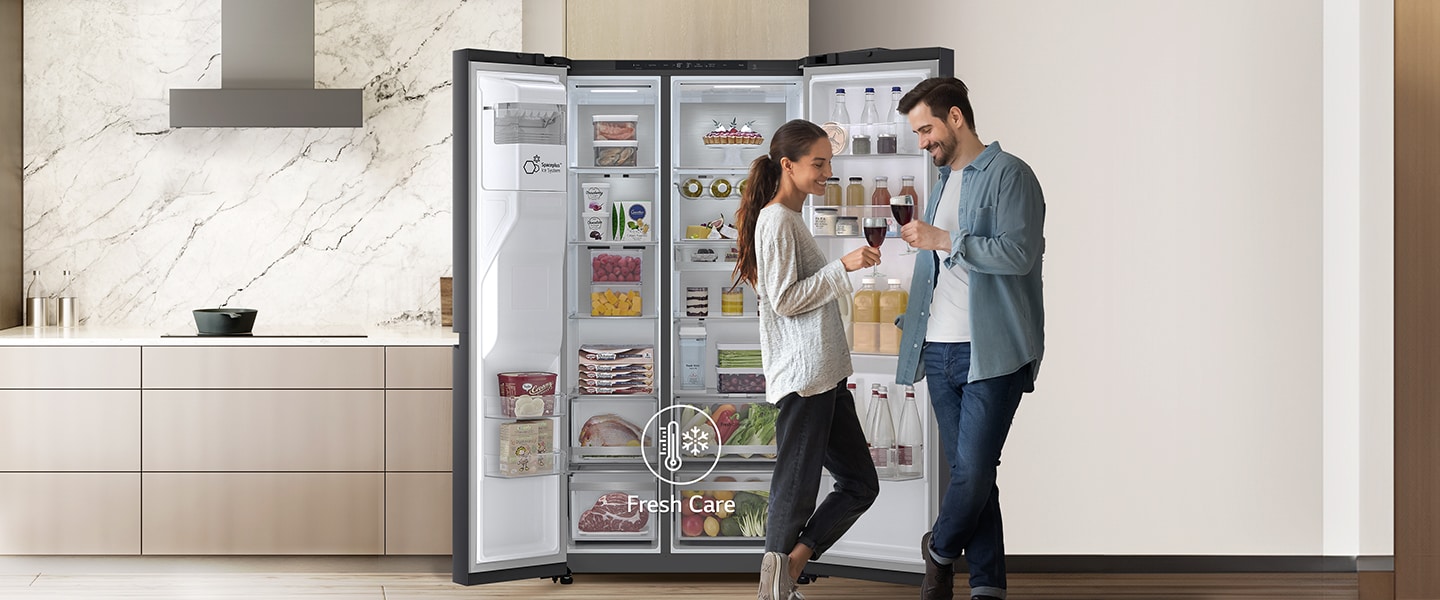Zwei Personen stehen vor einem weit geöffneten LG Side-by-Side Kühlschrank.