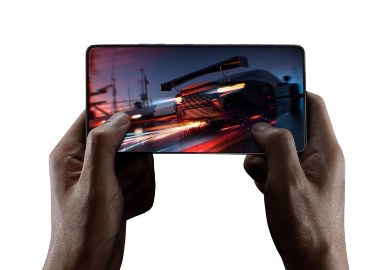 Nahaufnahme einer Hand, mit der jemand auf einem Mobiltelefon ein Autorennen-Spiel spielt.