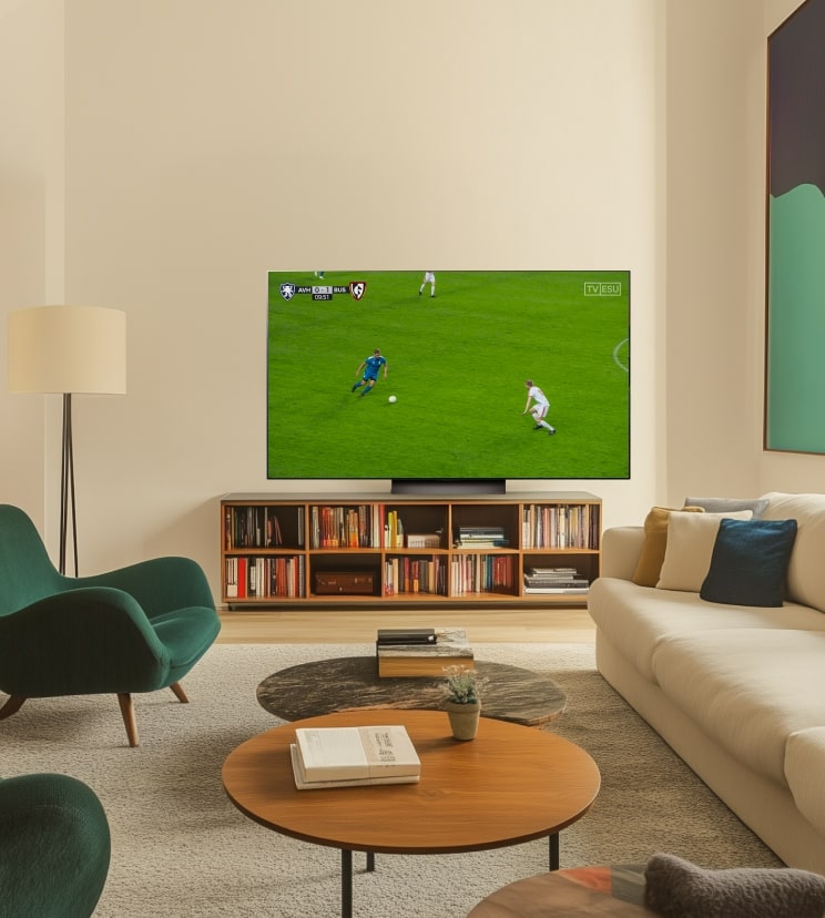 Ein LG OLED C4 Fernseher zeigt ein Fußballspiel in einem modernen Wohnzimmer.