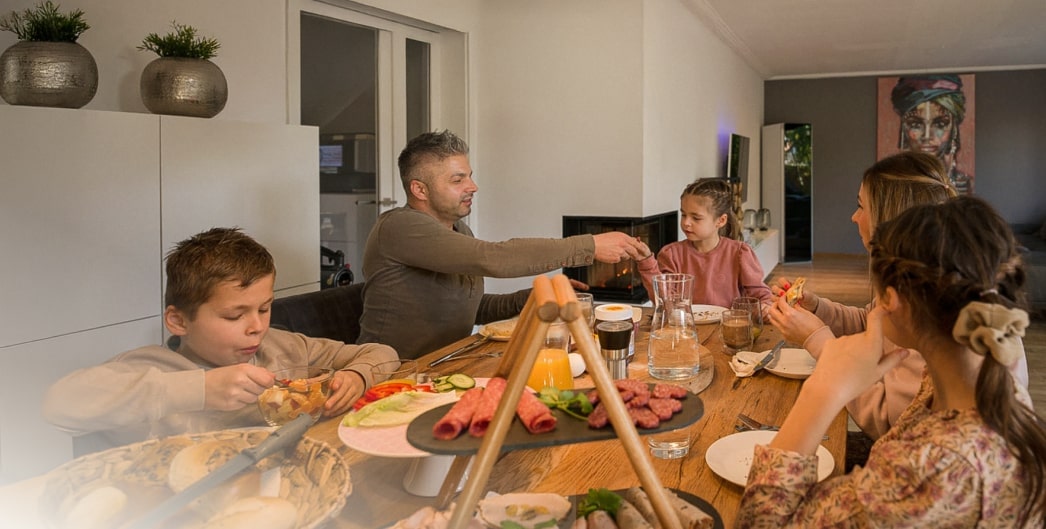 Eine Familie genießt gemeinsam das Abendessen und besondere Momente in einem gemütlichen Zuhause.