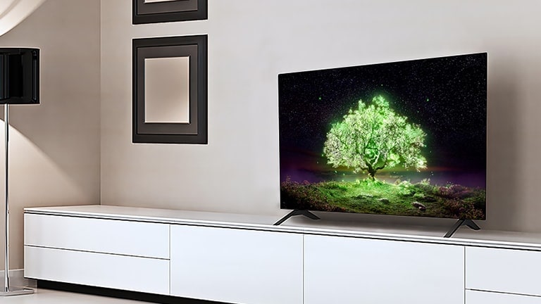 Ein Fernseher, der einen leuchtend grünen Baum anzeigt, steht in einem Wohnzimmer.