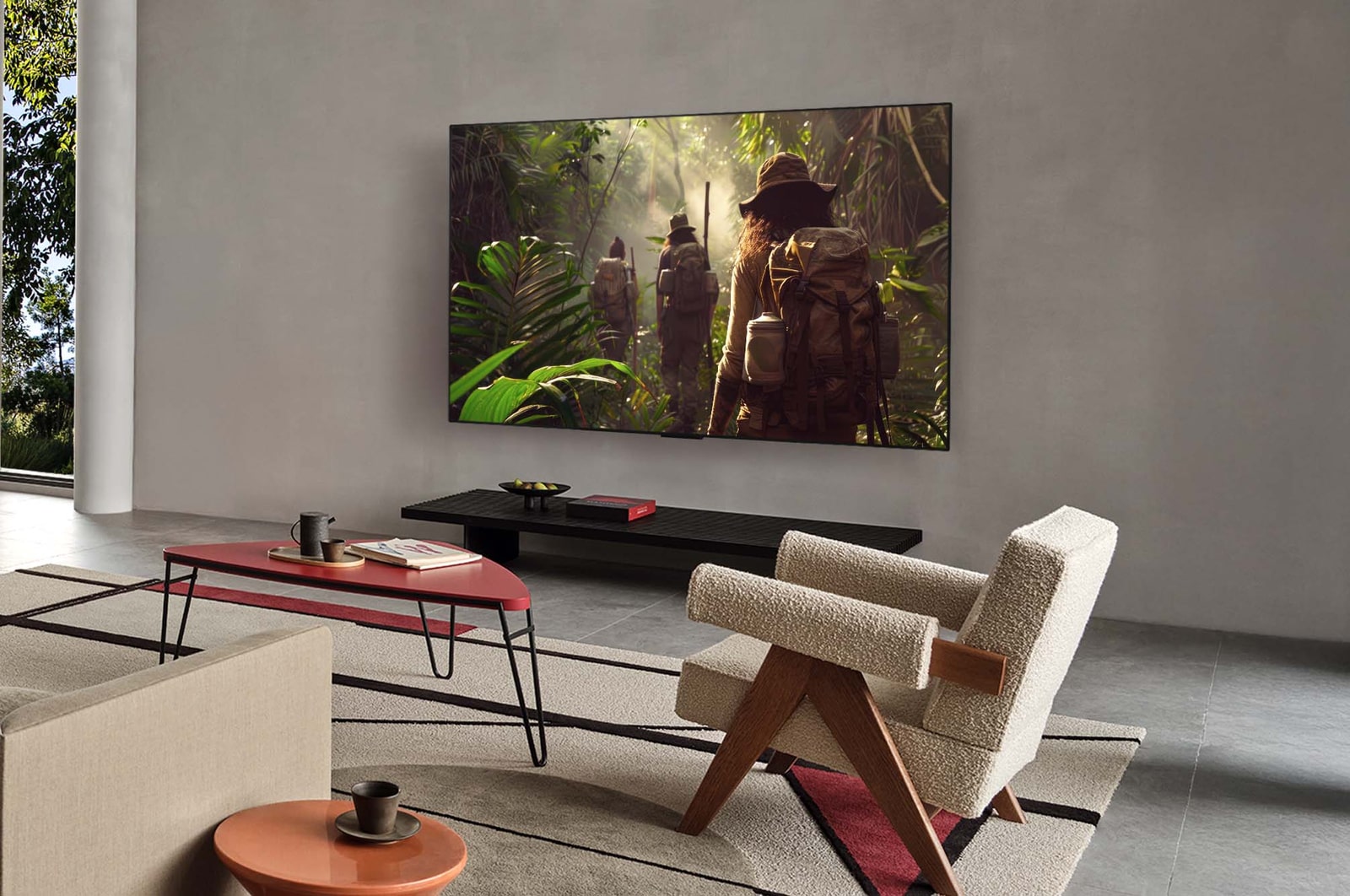 Bred visning af en stue i et luksushjem, hvor en mand ser en film på sit vægmonterede LG OLED TV. TV'ets design passer elegant til væggen og indretningen.