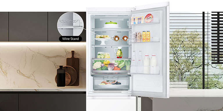 Køleskab med åben dør fyldt med frisk mad, hvor ses vinhylde.