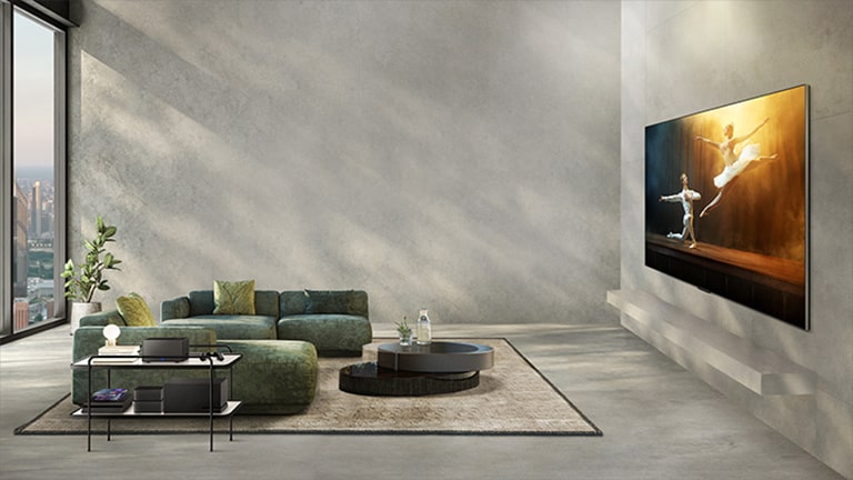 En video af LG OLED M3 på en grå væg i en moderne dagligstue, som afspiller ballet på skærmen. De rodede kabler, lydsystemet og spilkonsollerne er tilsluttet TV'et. Derefter forsvinder alt ekstraudstyr, og Zero Connect Box vises på et sidebord i rummet og giver et uforstyrret udsyn til skærmen.