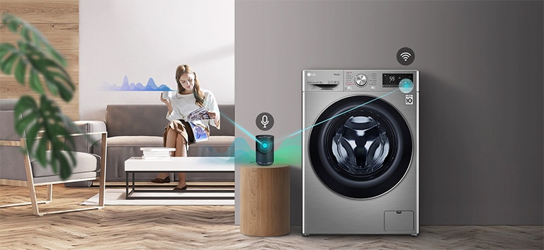 En kvinde der sidder i sofaen og drikker te og fortæller hvad vaskemaskinen skal gøre gennem sin AI-højttaler.