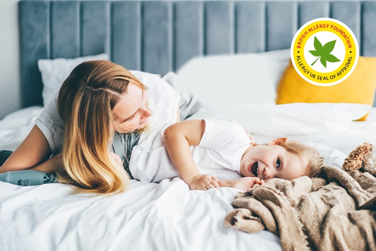 Barnet og moderen ligger på sengen.