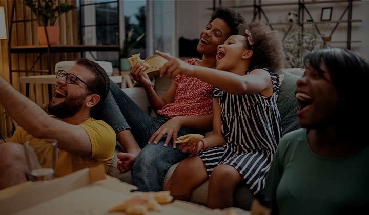 A group of friends gather in a huddle laughing.