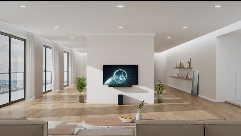 The Soundbar  and TV are hung on the white pillar in the center of the living room. On the wooden floor right under the Soundbar  a black wooper stands. On the left side there are floor-to-ceiling windows with great view and white curtains. On the right side there place wooden shelves with decorations and a picture places on the floor.