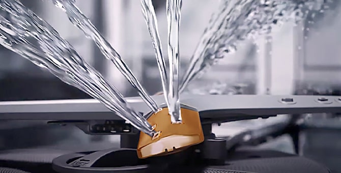 Intense water streams from dishwasher blades in close-up.