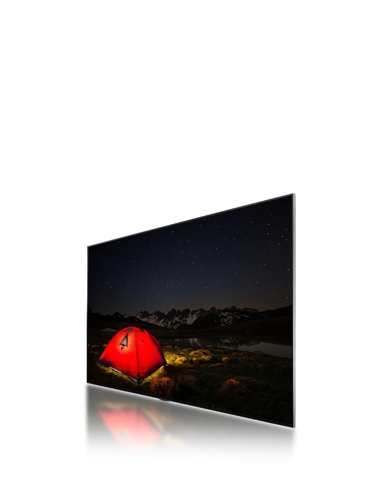 A side-angle view of an LG TV showing a dull, blurry image of a tent at night. A layer of the TV moves backward displaying big dimming areas, then smaller, blue dimming areas swipe across to replace them. The layer moves forward to reconnect to the LG TV, then the image of the tent becomes brighter and clearer.	