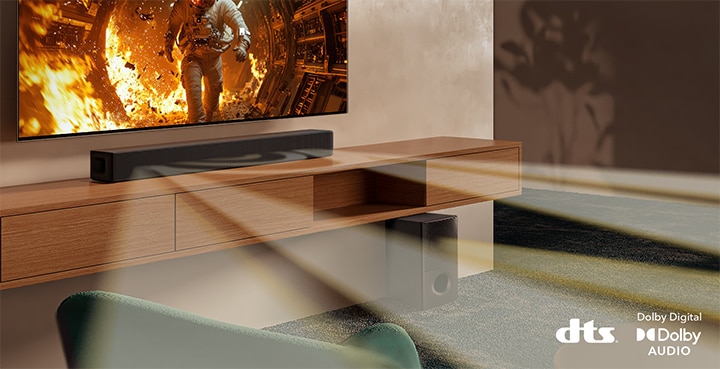 TV with scientific content is shown and SH5A soundbar is placed right below. On the floor the soundbar's sub woofer also stands. White semi-transparent sound waves are coming widely out of soundbar and the subwoofer. On the bottom right dts logo and Dolby Digital Audio logos are placed.