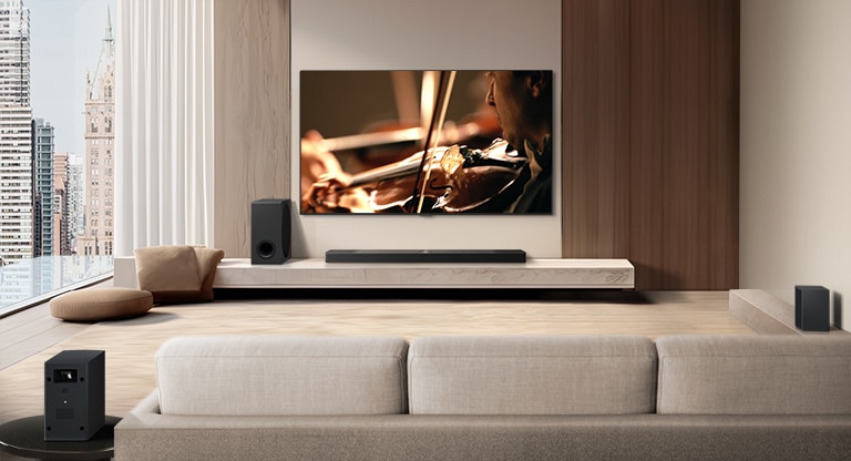 Televisor LG, barra de sonido LG, un subwoofer y altavoces traseros se encuentran en un moderno apartamento urbano. El fondo se atenúa y la superposición de cuadrícula aparece sobre la imagen del televisor LG, como un escaneo del espacio. Una línea punteada se extiende desde uno de los altavoces traseros, para mostrar que los dos altavoces traseros están de forma lineal. Las perlas blancas de sonido se unen para formar olas, llenando la habitación de sonido.