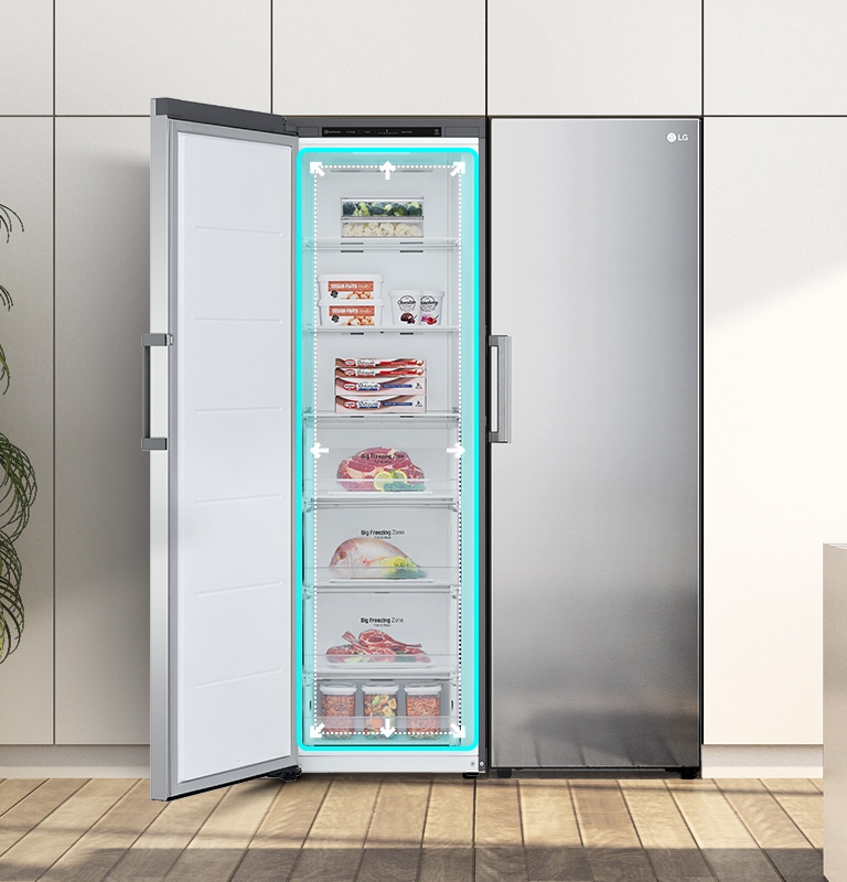 Congelador vertical LG abierto, lleno de alimentos, en cocina moderna con plantas y decoración blanca.