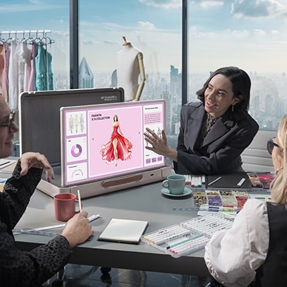 StanbyME Go está colocado en la sala de reuniones de la oficina. La pantalla muestra una presentación de moda. Una mujer toca la pantalla.