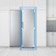 La vista frontal del frigorífico se muestra en una cocina. Un cuadrado azul en el borde del frigorífico con flechas indica cómo encaja perfectamente en una cocina estándar.