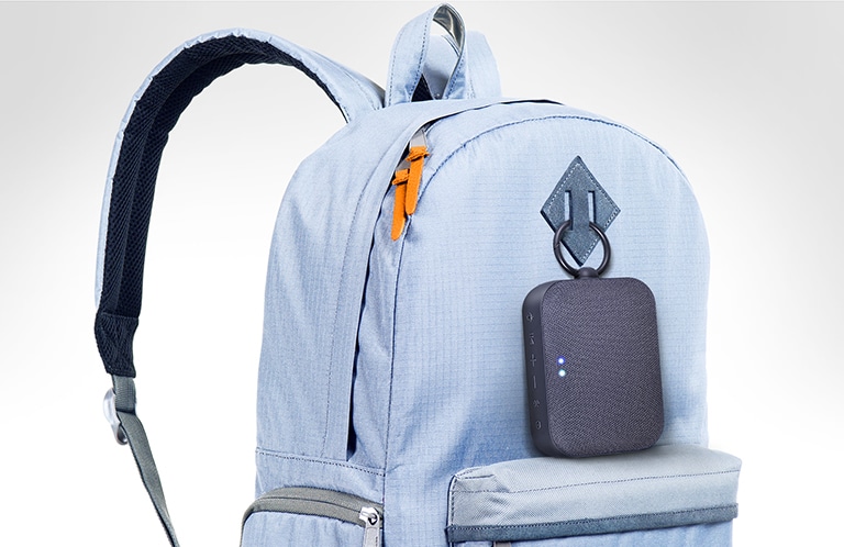 El LG XBOOM Go PN1 se sujeta a la mochila de color azul cielo.