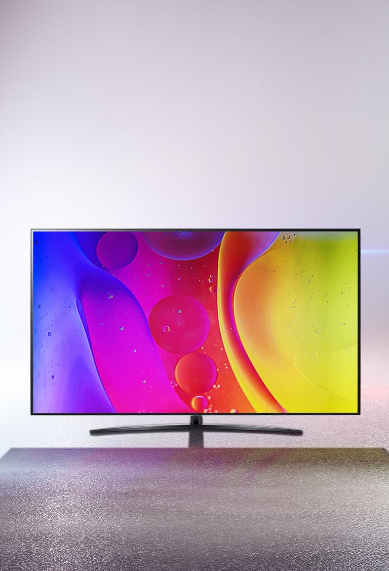 Imagen de un televisor en una habitación blanca con un imágen multicolor en la pantalla.