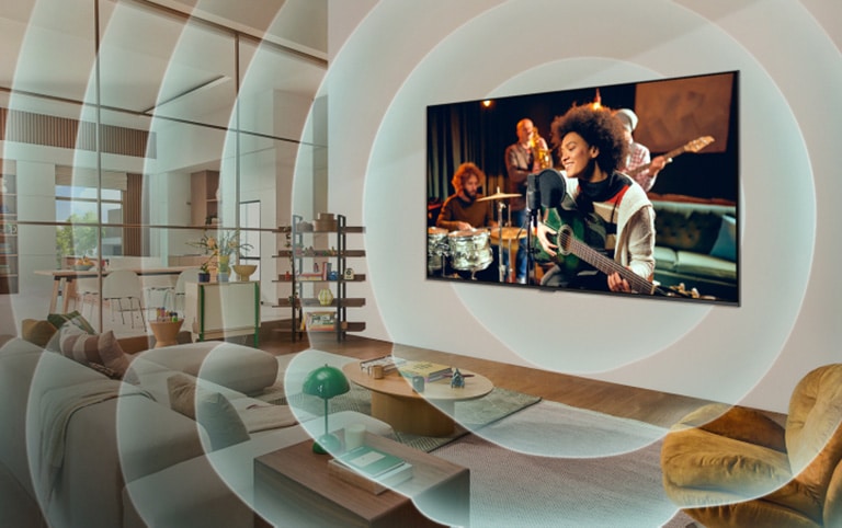 Televisor LG montado en una pared en una sala de estar con un guitarrista que se muestra en la pantalla. Gráficos de círculos concéntricos que representan ondas sonoras.