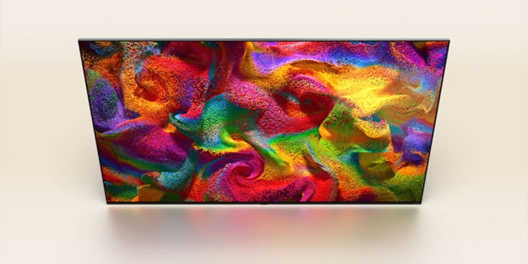 Las partículas de color estallan en la pantalla y, a continuación, los píxeles se transforman lentamente en un primer plano de una pared pintada con un patrón de colores en la pantalla del televisor LG.