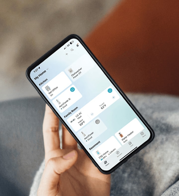 Una persona sostiene un smartphone con la aplicación LG ThinQ abierta, gestionando dispositivos del hogar inteligente mientras toma café.
