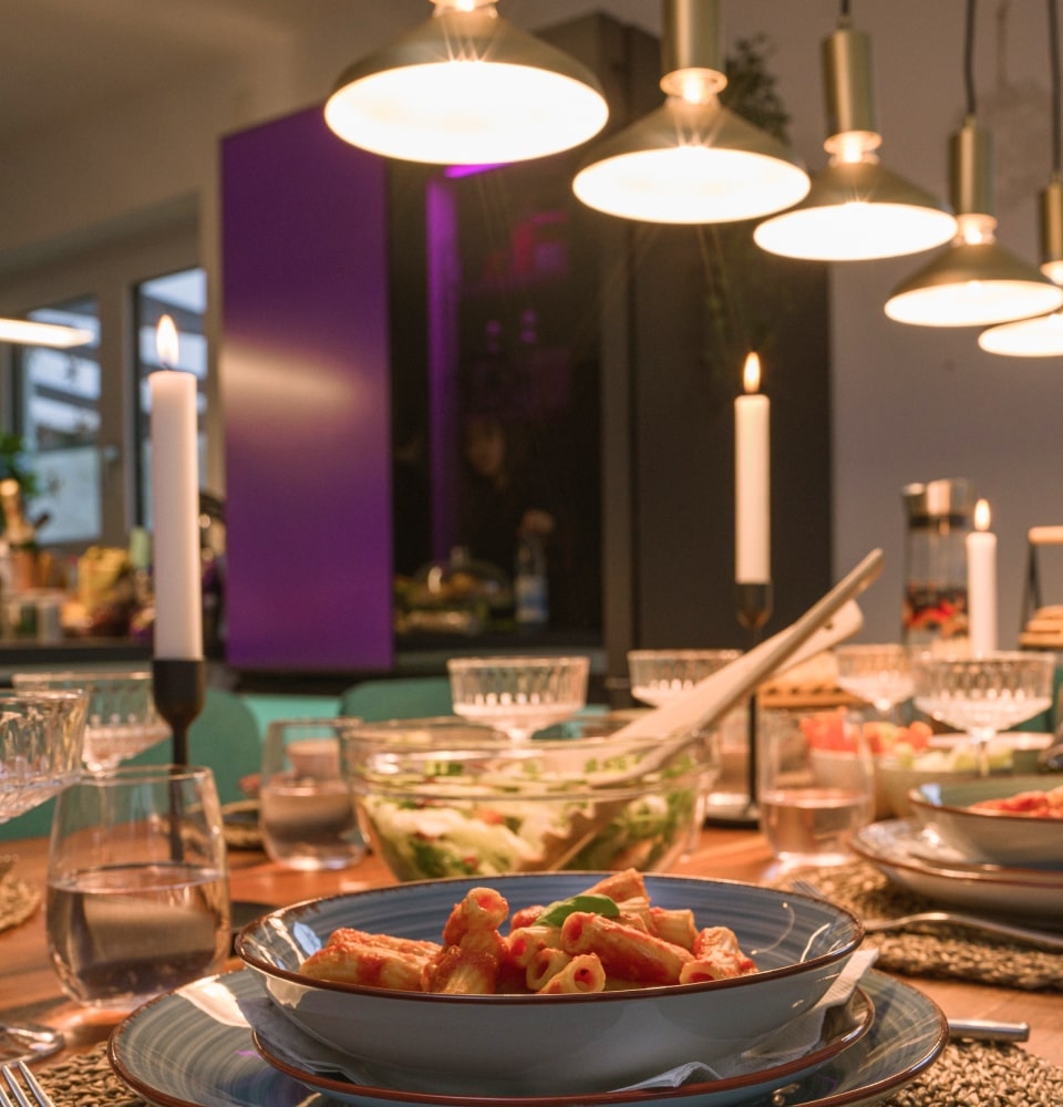 La mesa del comedor, adornada con comida, se refleja junto con el LG MoodUP Refrigerator.