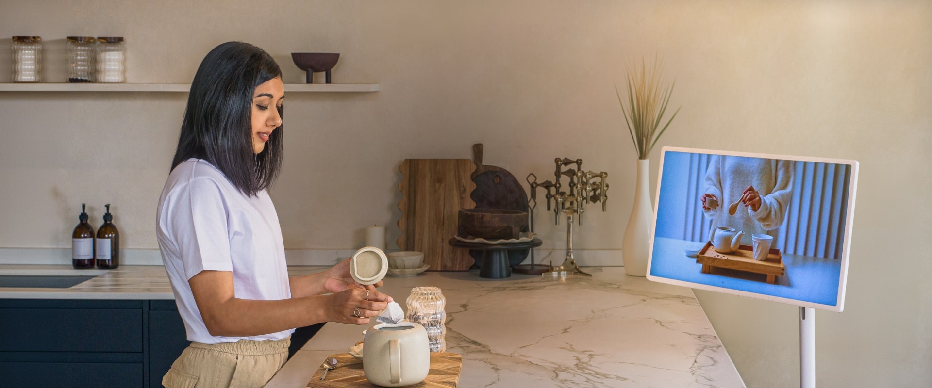 Lisa Mistry está preparando té en la barra del desayuno, viendo un video sobre cómo hacer té en su LG StandbyME.