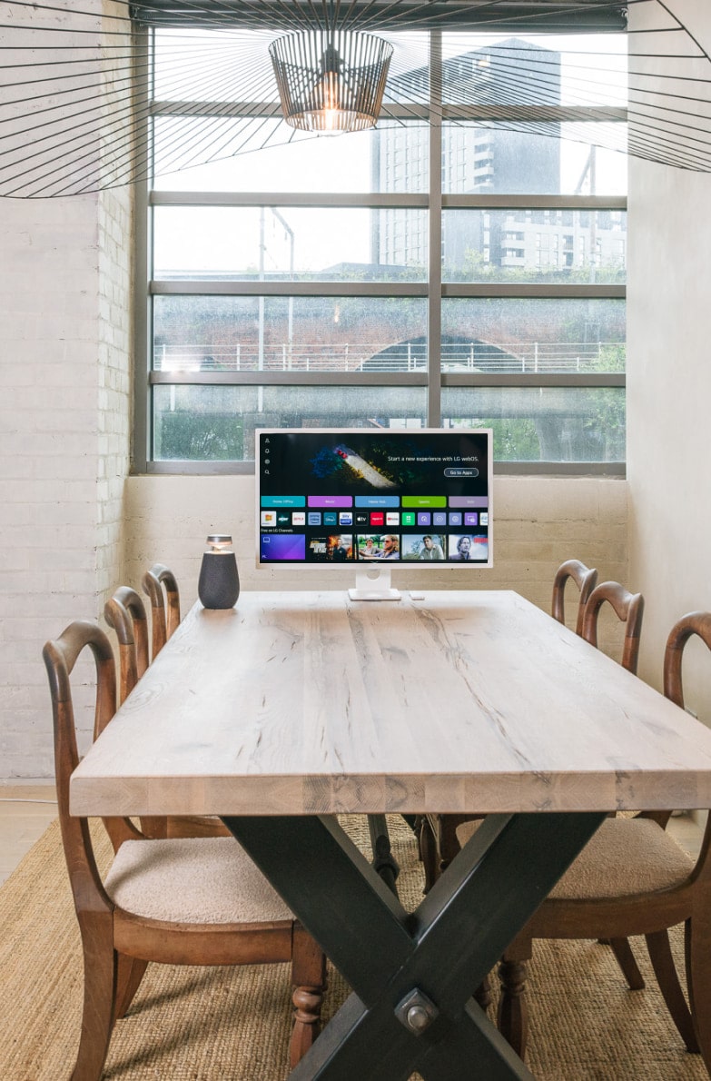 En la barra del comedor, el LG MyView Smart Monitor y el Xboom XO2T están colocados uno al lado del otro en un entorno minimalista.