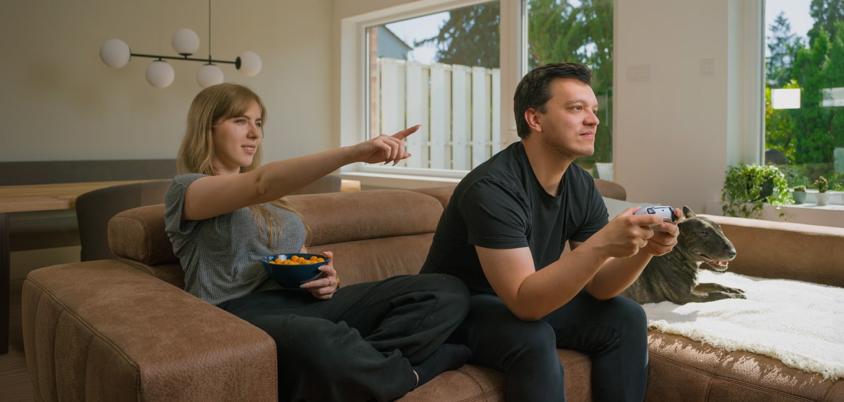 Pareja disfrutando de un videojuego en un salón luminoso con un televisor LG OLED, creando momentos compartidos de diversión y relajación.