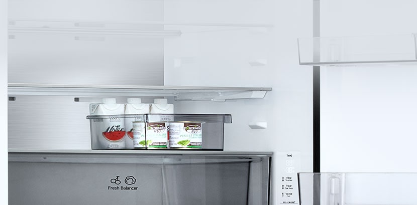 Vista interior de un congelador inferior LG con una cesta deslizante transparente que contiene seis botellas pequeñas de salsa.