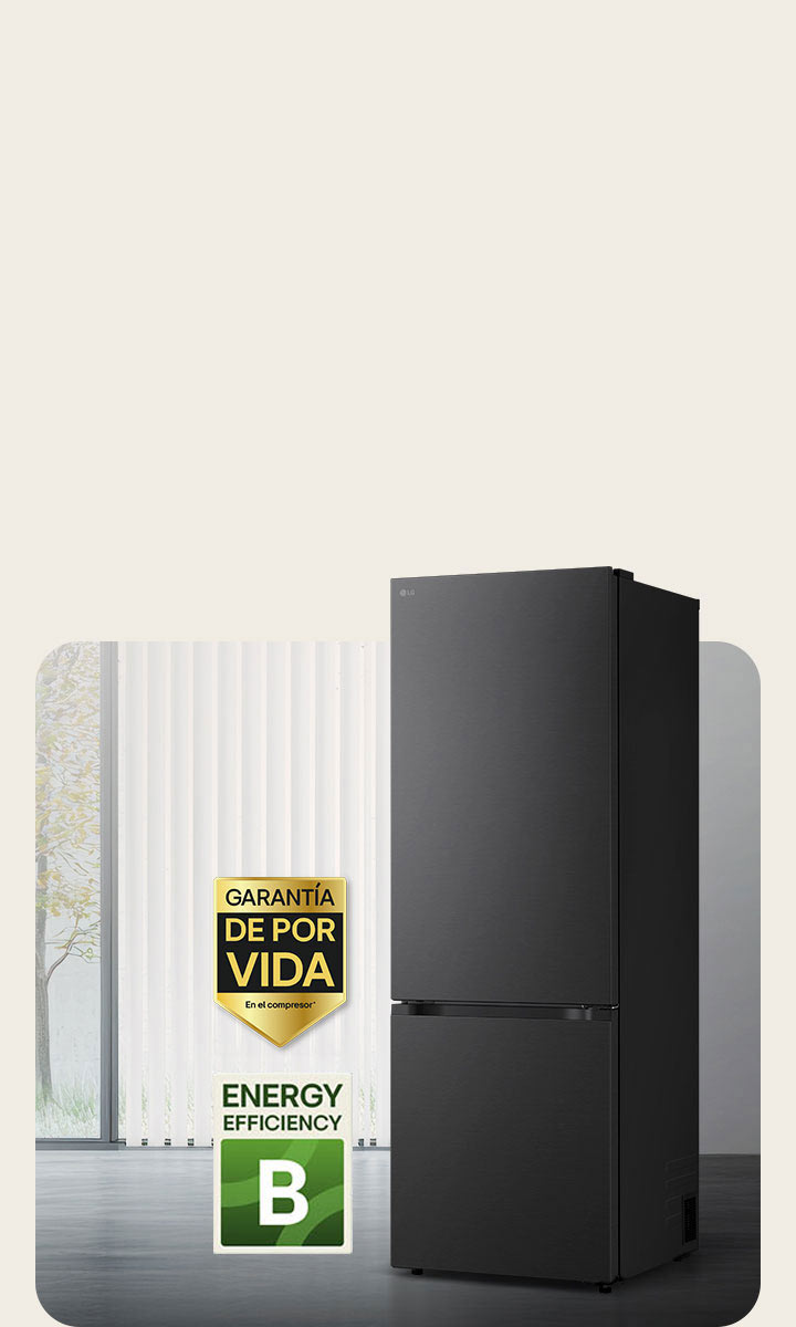 Vista frontal de un congelador inferior LG negro mate, colocado en una habitación luminosa con persianas verticales. A continuación se muestran la garantía de 10 años del compresor y los iconos de eficiencia energética A.
