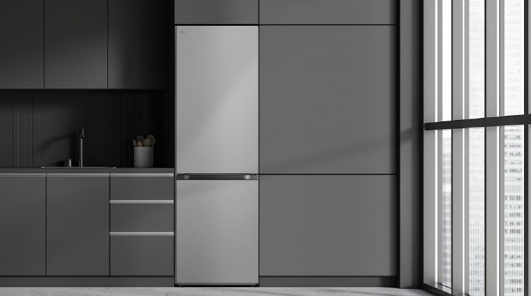 Cocina moderna con frigorífico LG a la derecha, encimeras grises y ventana amplia a la derecha.
